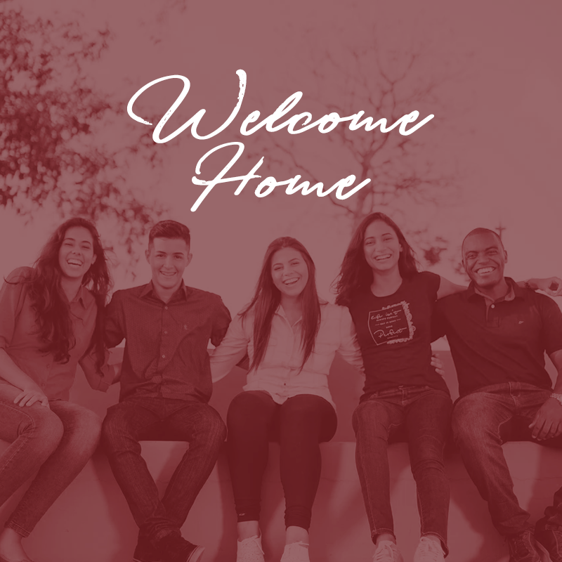 A group of friends sitting below the words "Welcome Home"