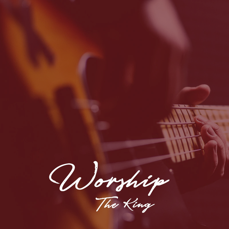 A man playing a guitar with the wors "Worship the King"